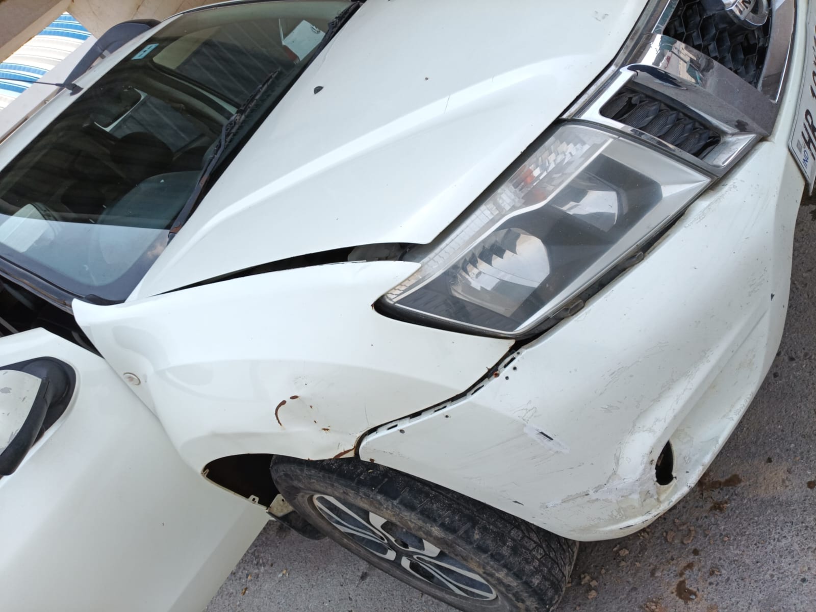 White Nissan Terrano front bumper, fender, and headlight damage