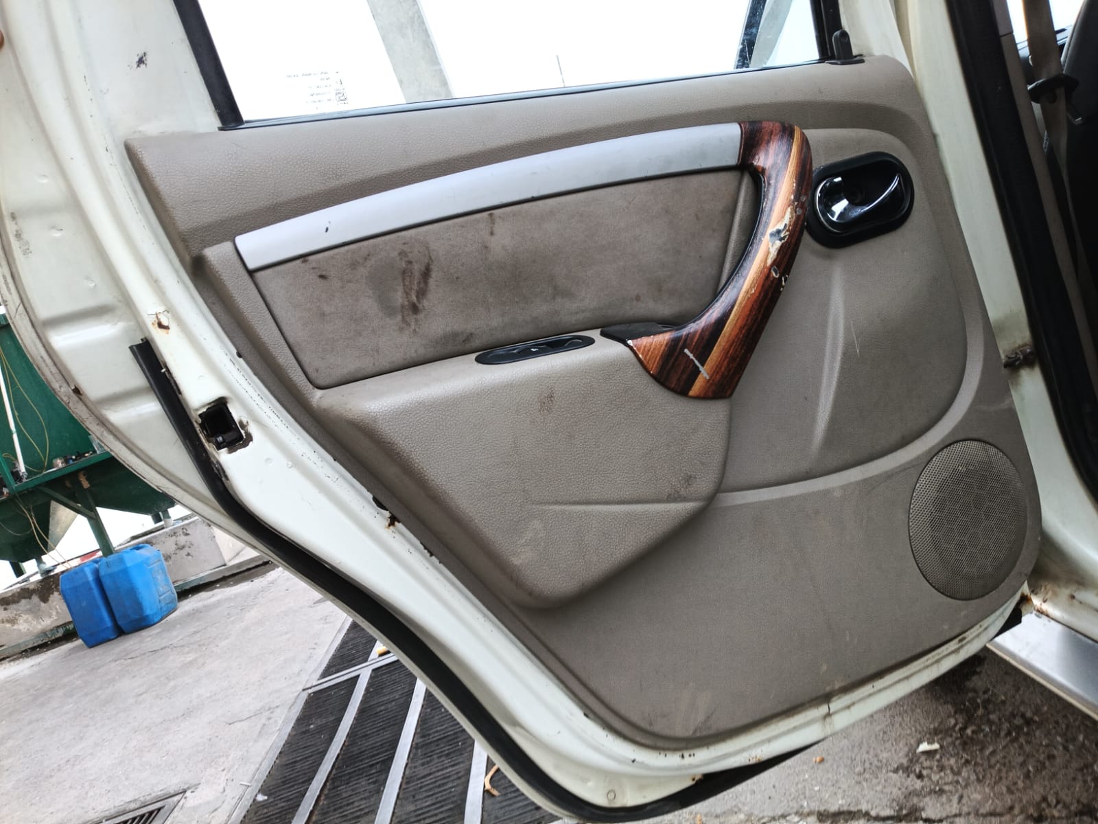 Rear door panel with marked fabric and worn wood finish trim
