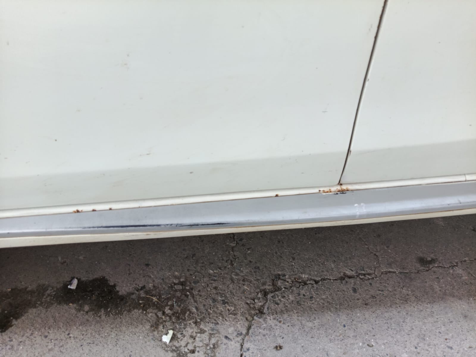 Close view of side sill rust spots near lower door line