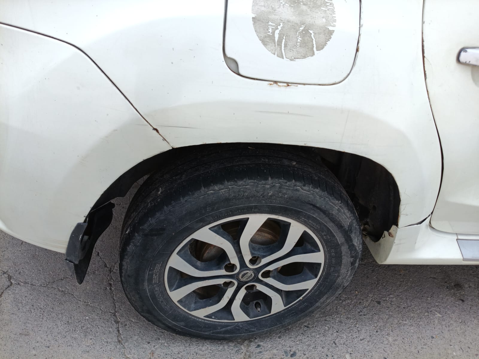 Rear wheel arch and fuel lid area showing scuffs and rust marks
