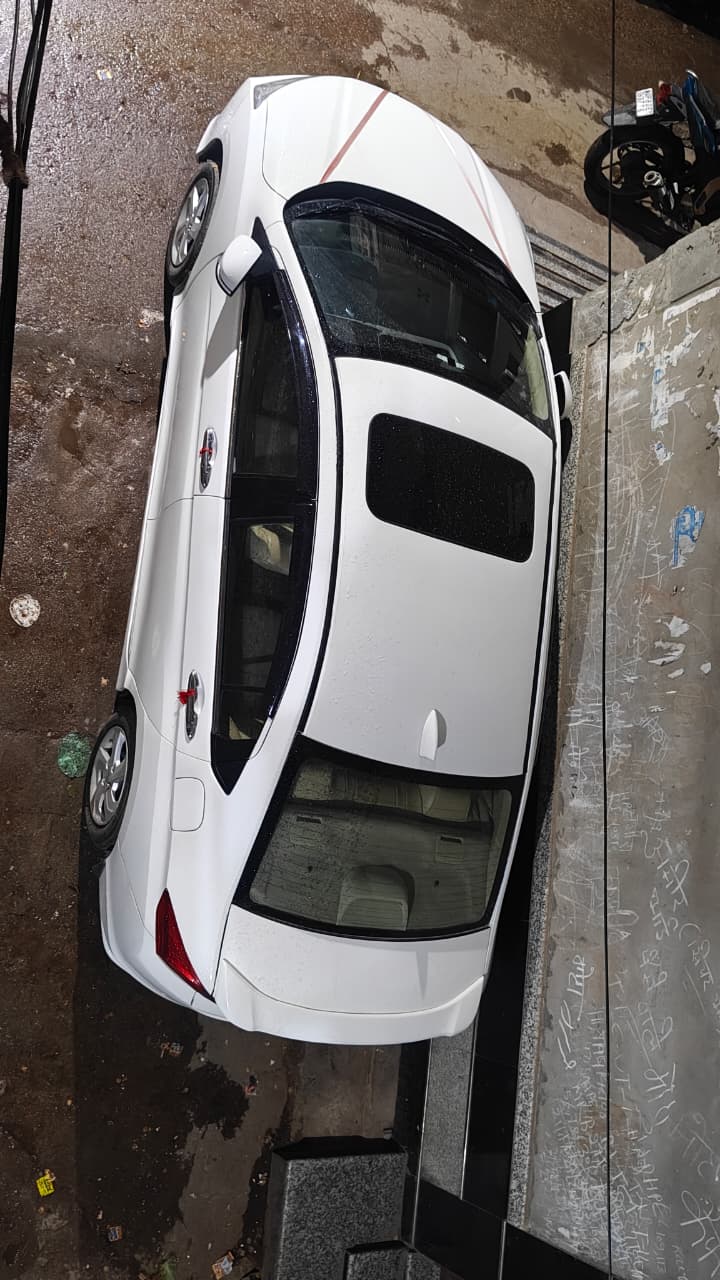 White sedan photographed from above in a narrow parking lane