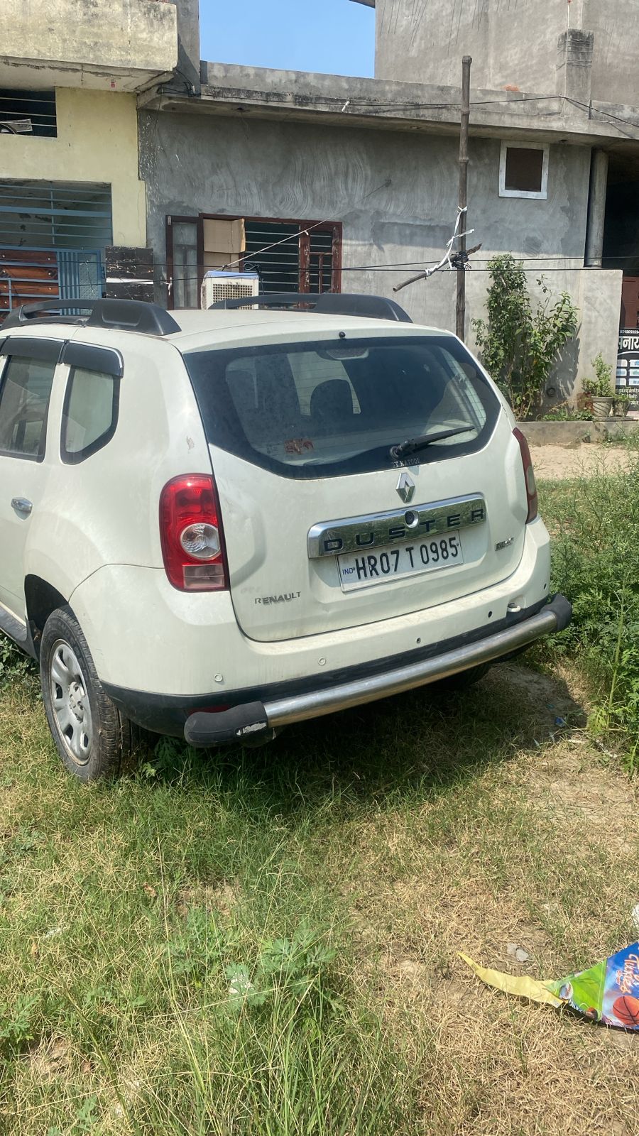 White Renault Duster rear view parked on grass