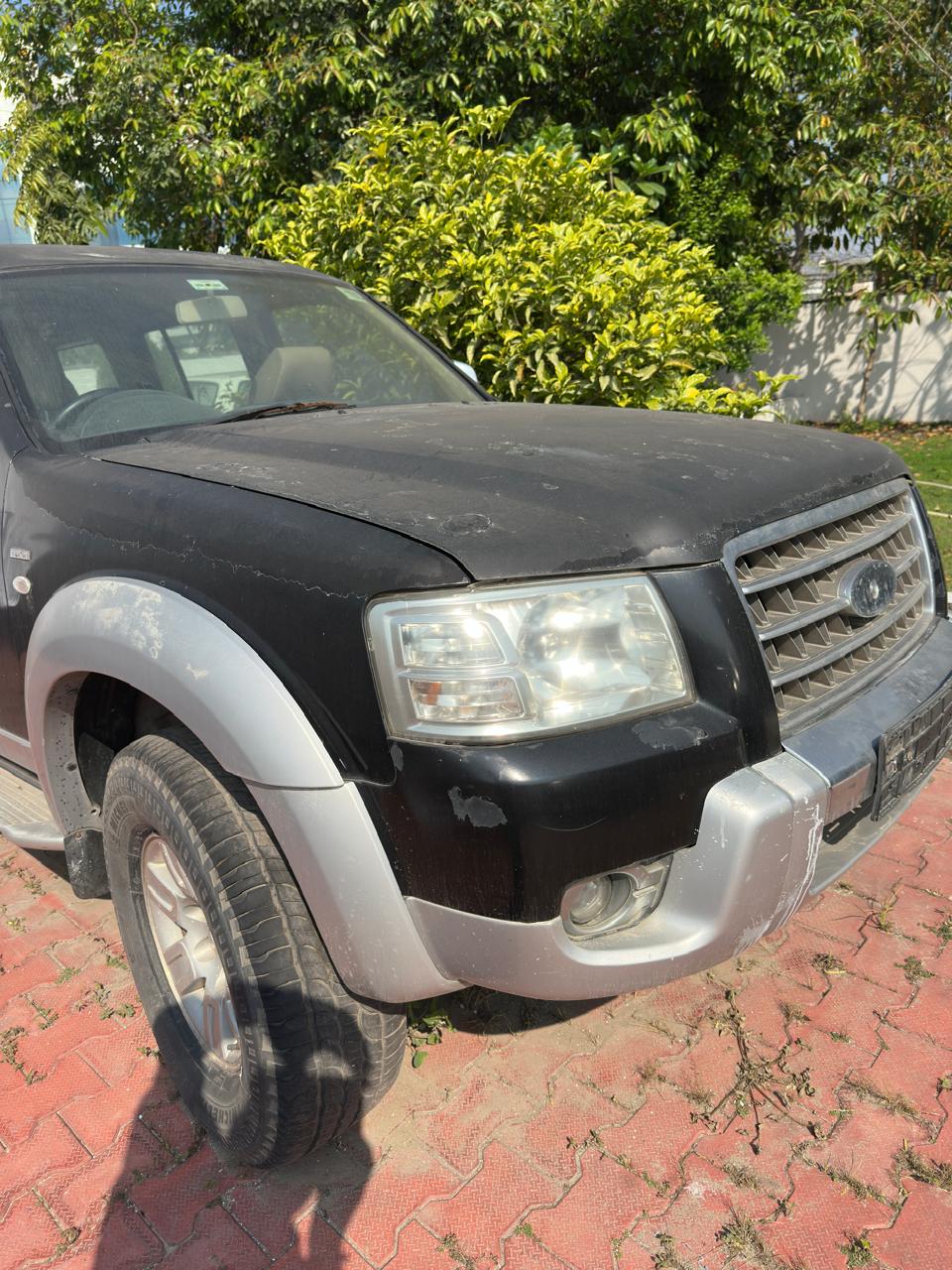 Black and silver Ford SUV front view with headlight and bumper wear