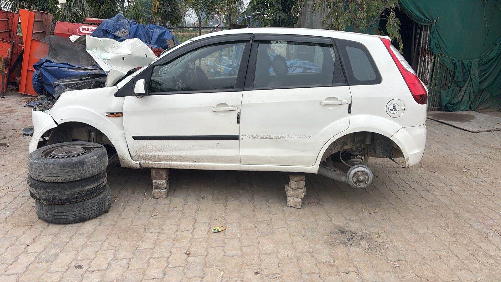 Ford Figo side view on blocks during dismantling with wheels removed