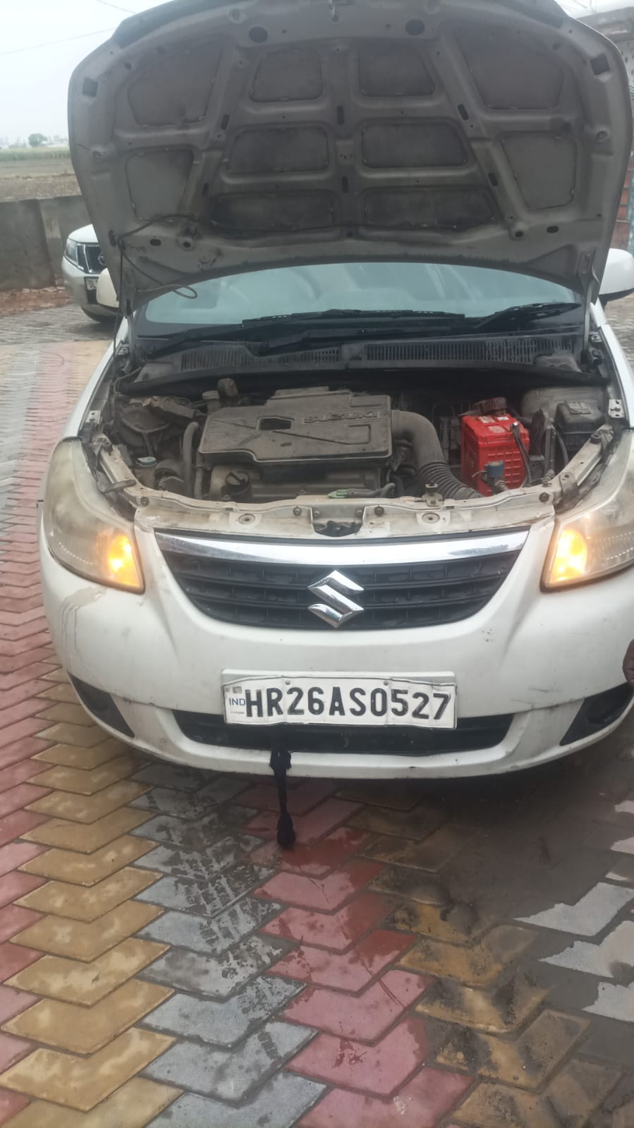 White Suzuki engine bay with open bonnet and battery visible